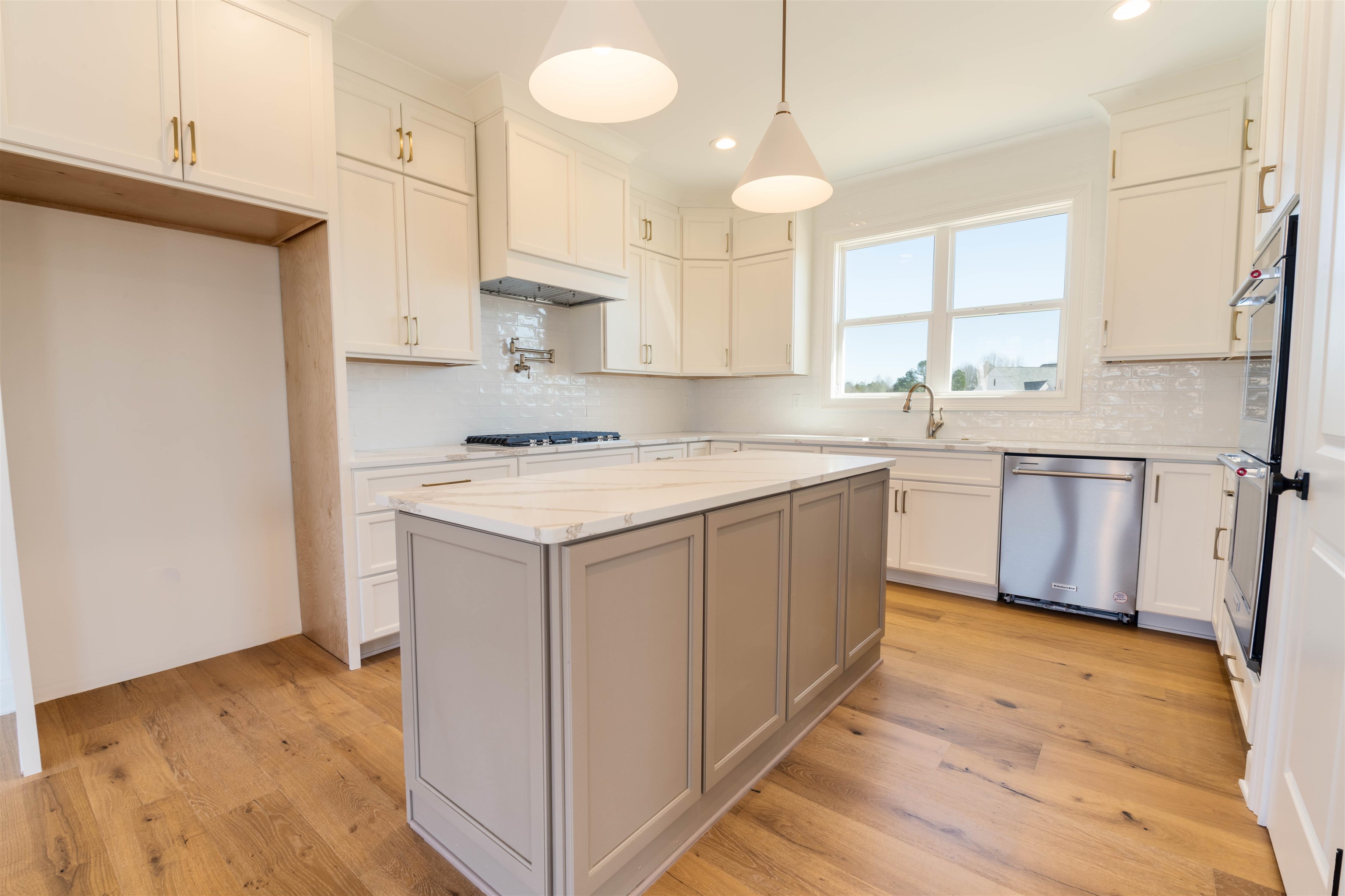 30 Rambling Rex Trail Piperton, TN 38017 - Photo 10 of 25 Kitchen with light wood-style flooring, a center island, gas cooktop, and stainless steel dishwasher
