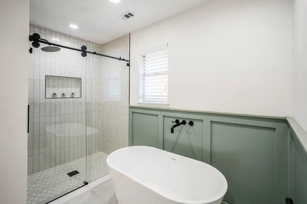 a bathroom with a shower a toilet and a window
