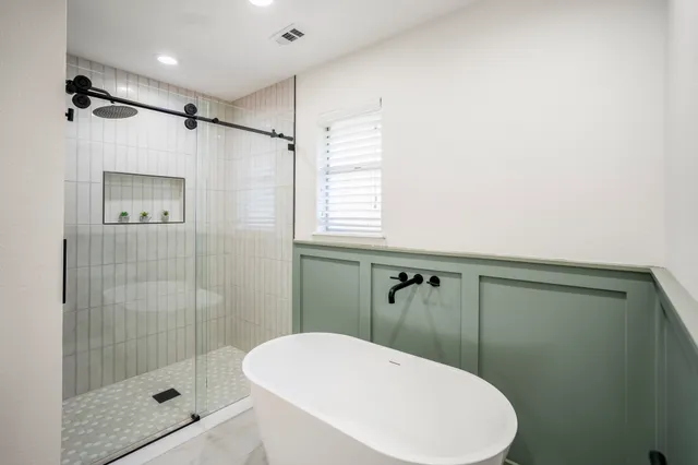 a bathroom with a shower a toilet and a window