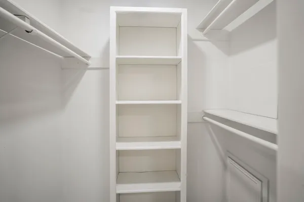 a view of walk in closet with empty racks
