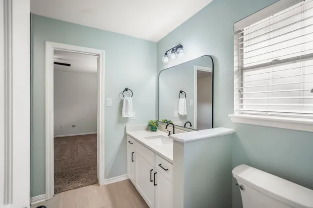 a bathroom with a double vanity sink toilet and a window