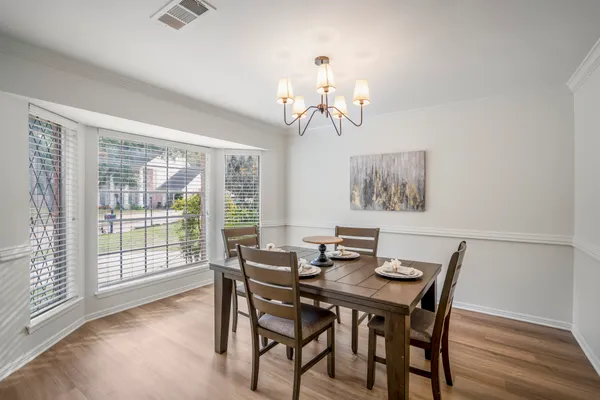 a view of a dining room with furniture wooden floor and chandelier
