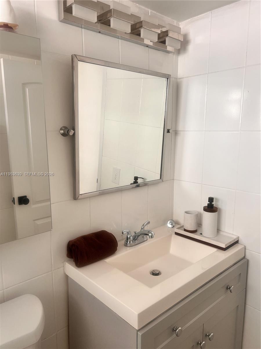 1300 Lincoln Road, Unit B902 Miami Beach, FL 33139 - Photo 10 of 17 a bathroom with a sink toilet and mirror