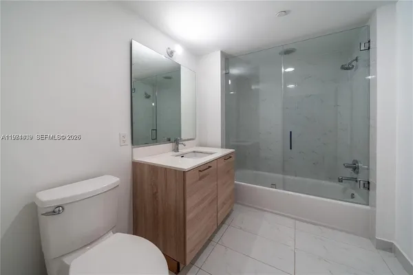 a bathroom with a double vanity sink toilet and shower