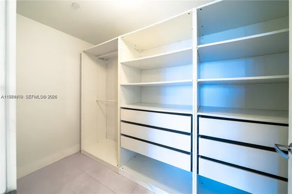 a view of walk in closet with empty racks
