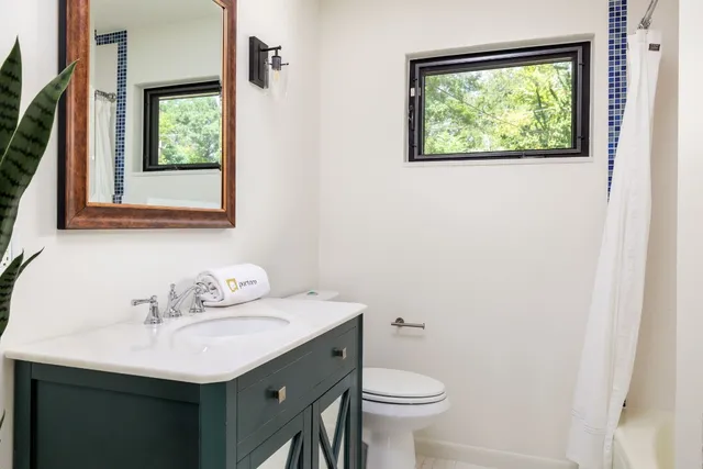 a bathroom with a sink mirror and toilet
