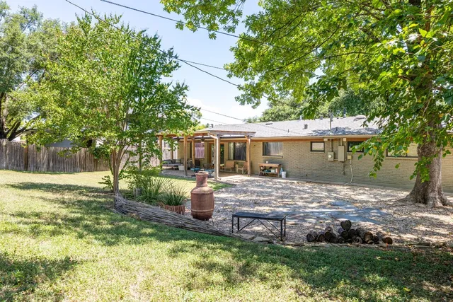 a view of a house with backyard and a tree