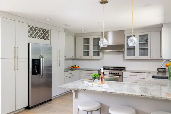 a kitchen with stainless steel appliances granite countertop a refrigerator a sink a stove and cabinets