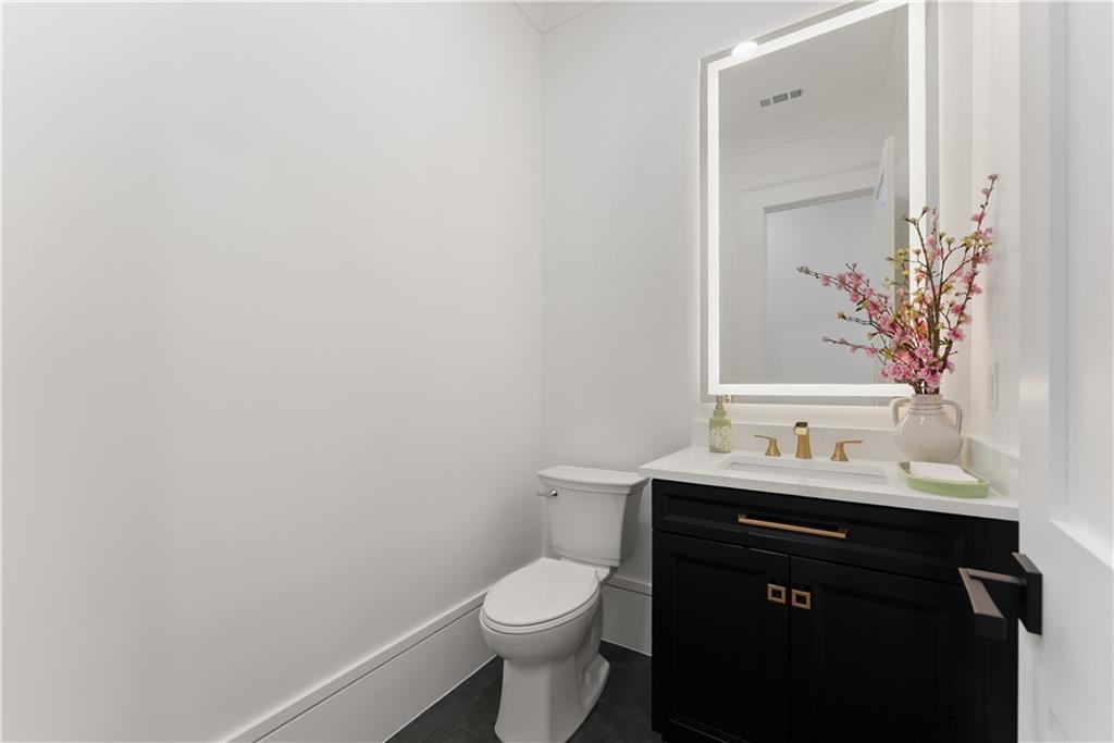 2366 Wall Road Monroe, GA 30656 - Photo 29 of 186 a bathroom with a granite countertop toilet sink and mirror