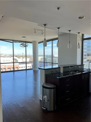 a kitchen with a large window and wooden floor