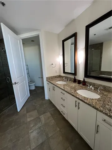 a spacious bathroom with a granite countertop sink and a mirror