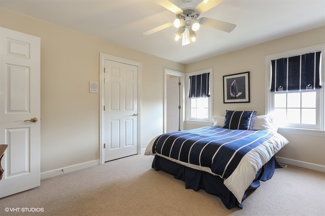 6040 South Grant Street Burr Ridge, IL 60527 - Photo 16 of 25 a spacious bedroom with a large bed and a chandelier