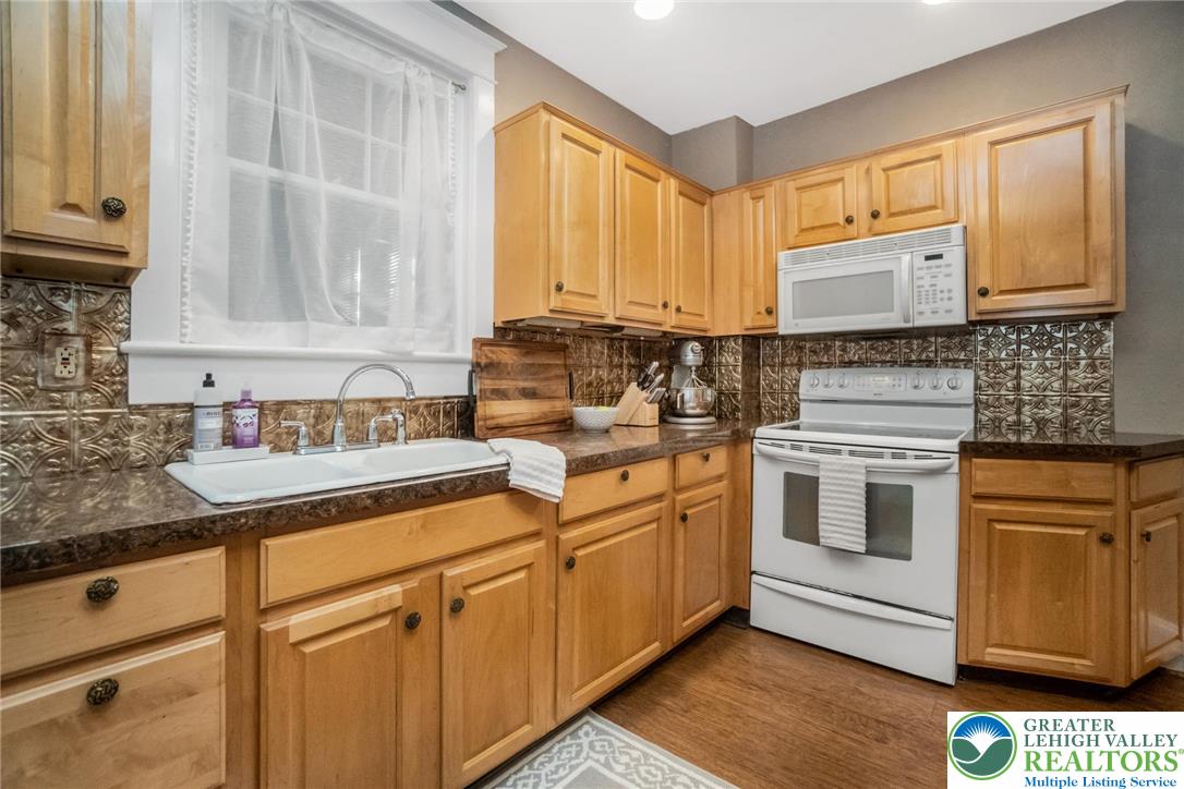 1209 Maple Street Bethlehem, PA 18018 - Photo 17 of 46 a kitchen with granite countertop white cabinets and white appliances