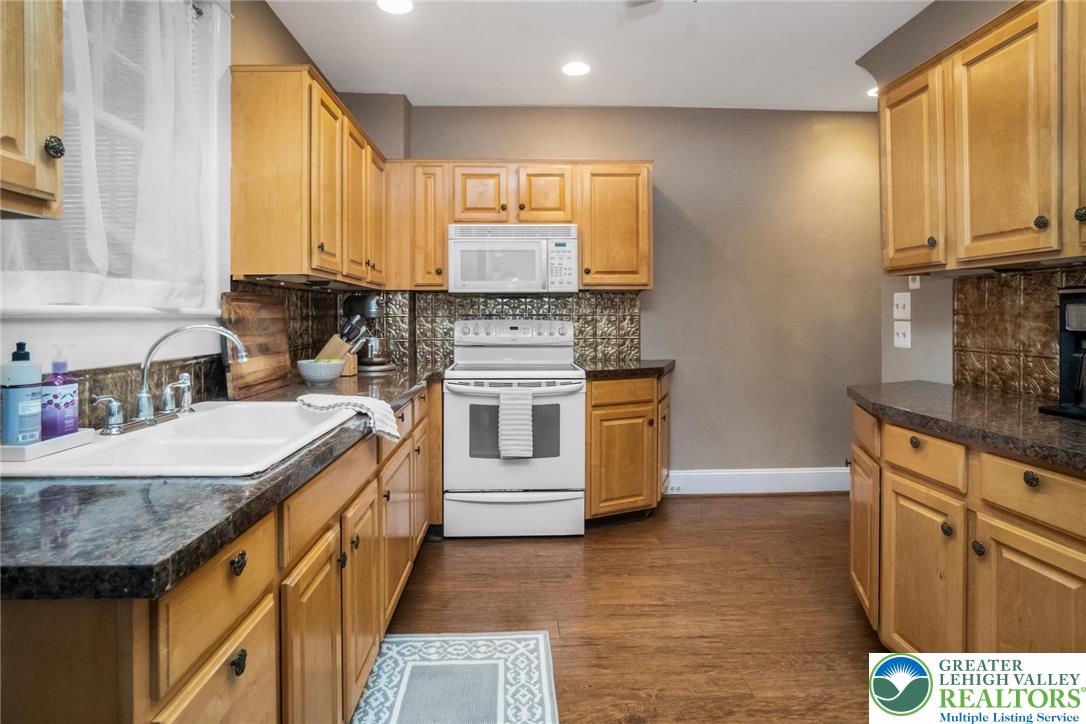 1209 Maple Street Bethlehem, PA 18018 - Photo 18 of 46 a kitchen with stainless steel appliances granite countertop a sink a stove and a wooden floors