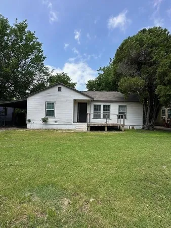 a front view of house with a garden and deck