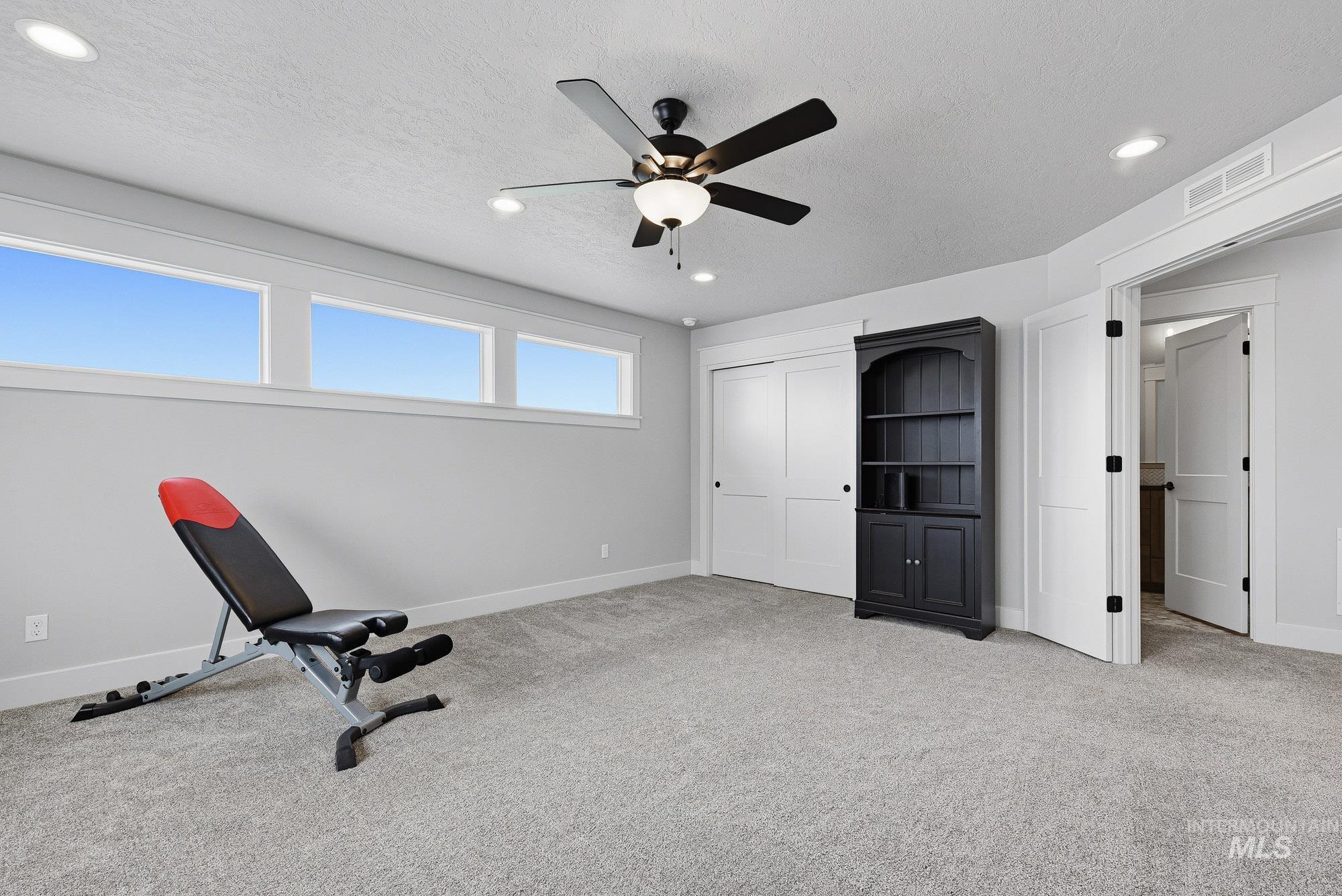 5676 East Zaffre Ridge Street Boise, ID 83716 - Photo 36 of 50 Carpeted room featuring a ceiling fan with integrated lighting, recessed lighting, and three high-set windows