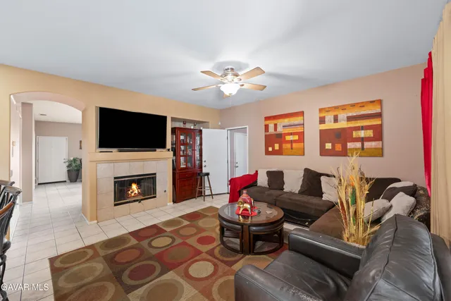 a living room with furniture a fireplace and a flat screen tv