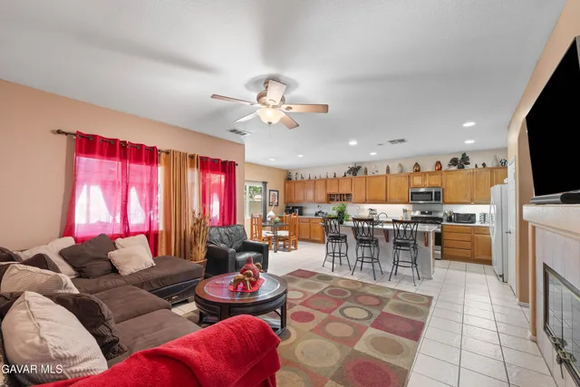 a living room with furniture kitchen view and a flat screen tv