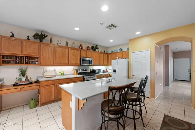 a kitchen with a sink a table and chairs in it