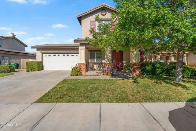 a front view of a house with a yard and a garage