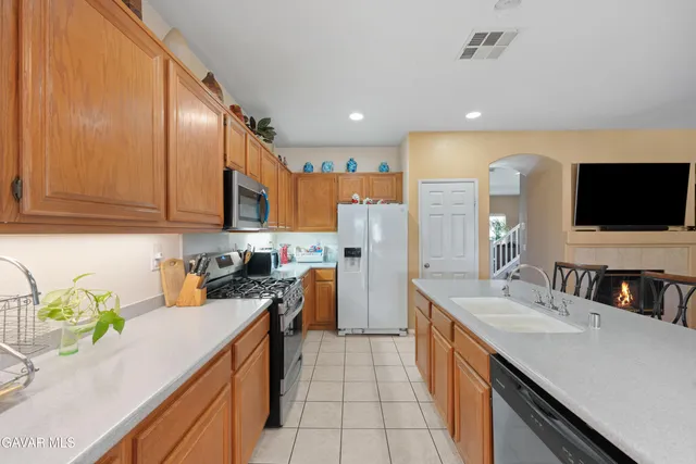 a kitchen with a sink a counter top space stainless steel appliances and cabinets