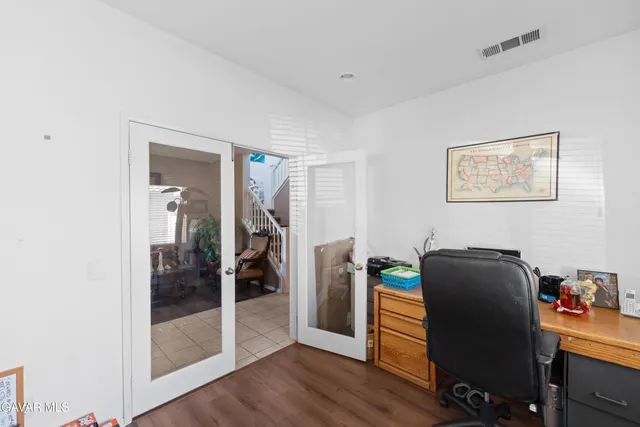 a view of a workspace with furniture and wooden floor