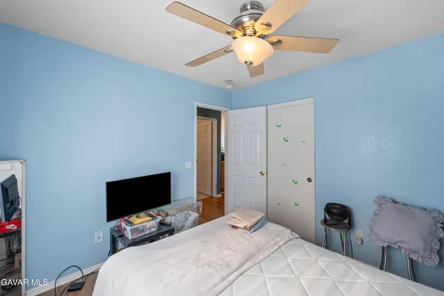 a bedroom with a bed and a flat tv screen on the dresser