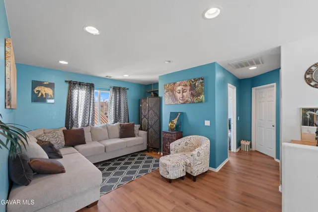 a living room with furniture and wooden floor