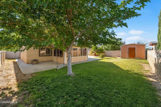 a view of a house with backyard and a tree