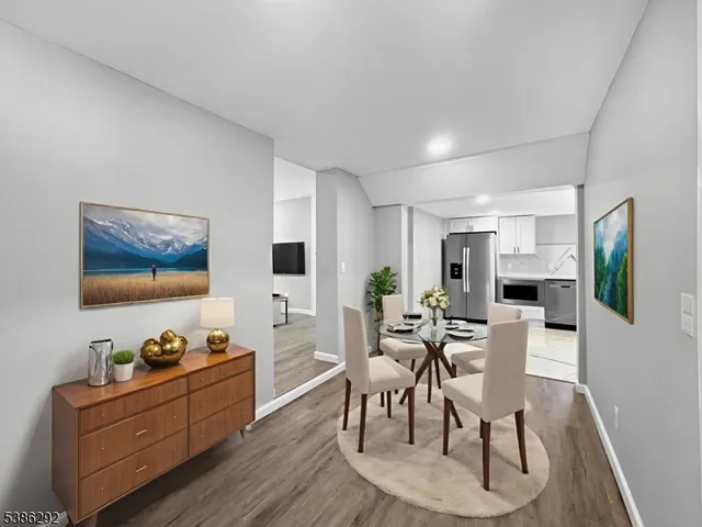 a view of a dining room with furniture a rug and wooden floor