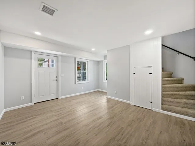 an empty room with wooden floor and white walls
