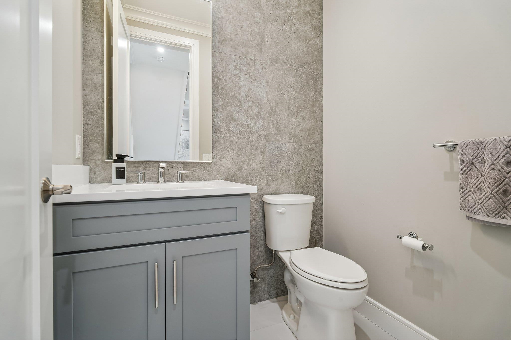 a bathroom with a toilet sink vanity and mirror
