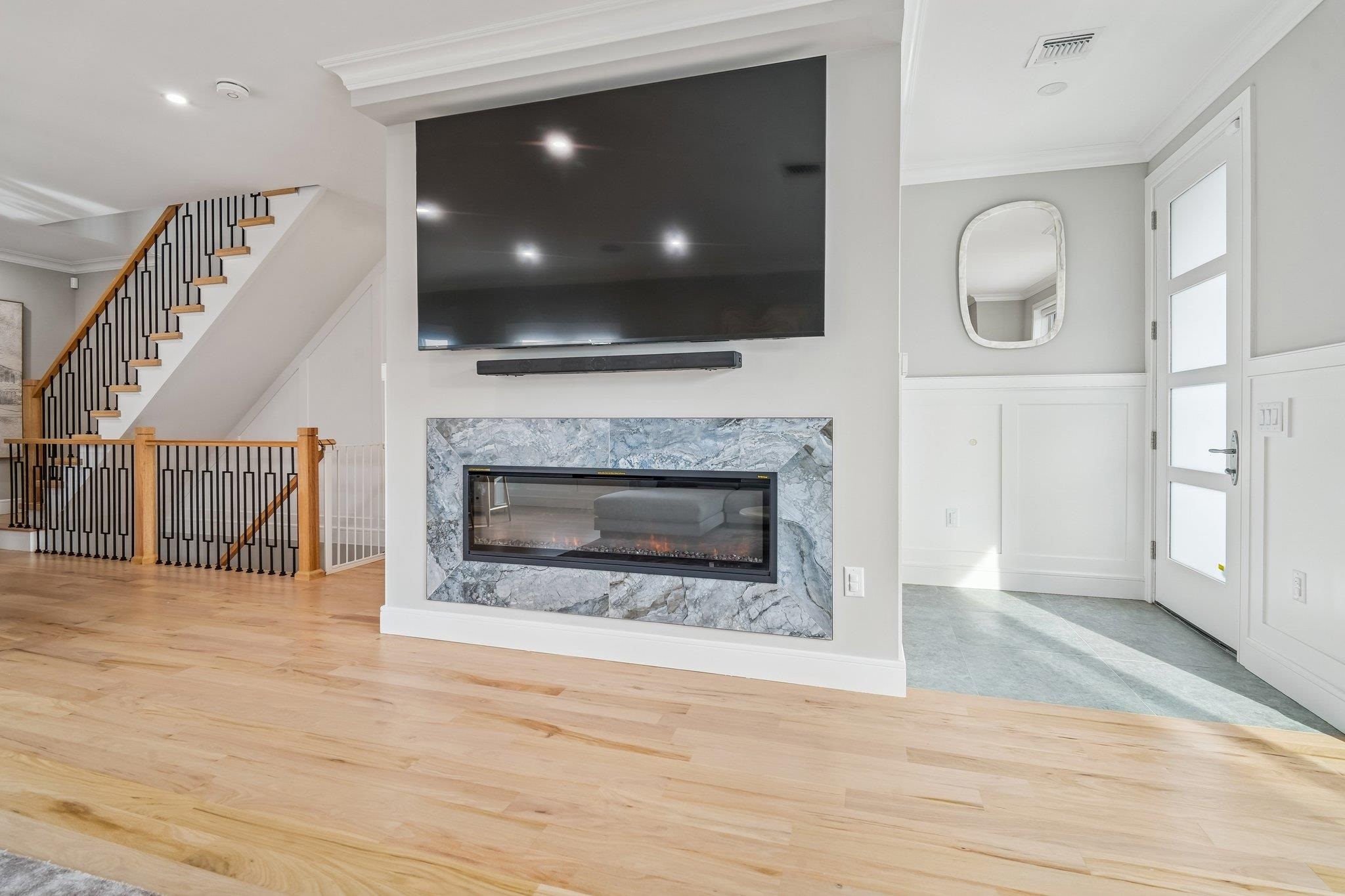 305 8th Street Fairview, NJ 07022 - Photo 5 of 27 a living room with a fireplace a flat screen tv and a fireplace
