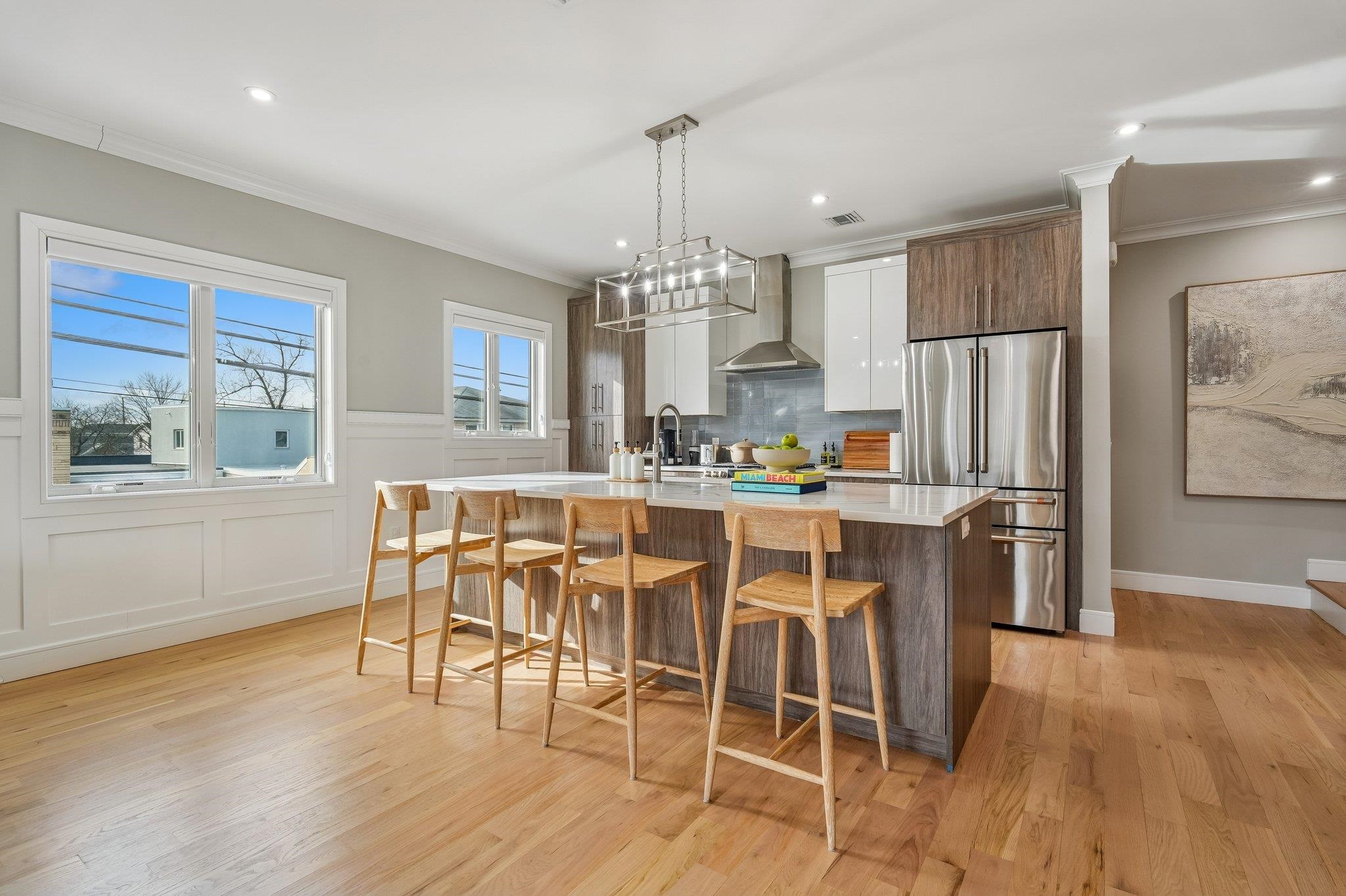 305 8th Street Fairview, NJ 07022 - Photo 7 of 27 a kitchen with stainless steel appliances granite countertop a dining table chairs refrigerator and cabinets