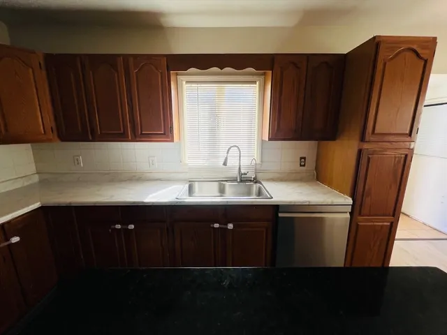 a kitchen with a sink a refrigerator and window
