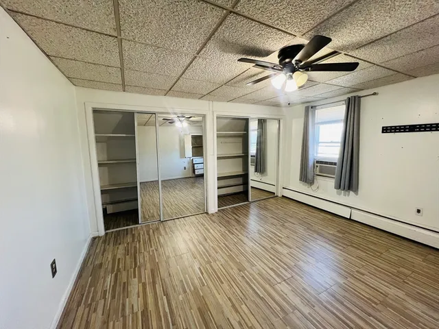 a view of empty room with wooden floor and windows