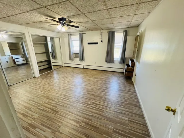 a view of empty room with wooden floor