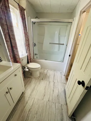 a bathroom with a toilet and a shower