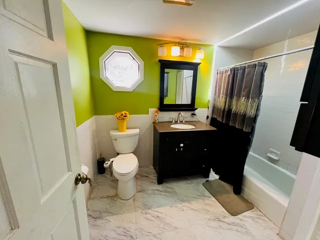 a bathroom with a toilet sink vanity and mirror