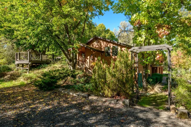 a view of a chair and table in backyard of the house