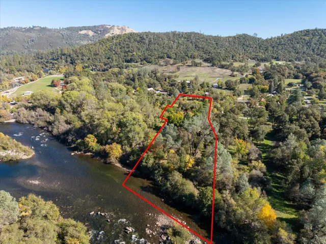 a view of a green field with trees in the background