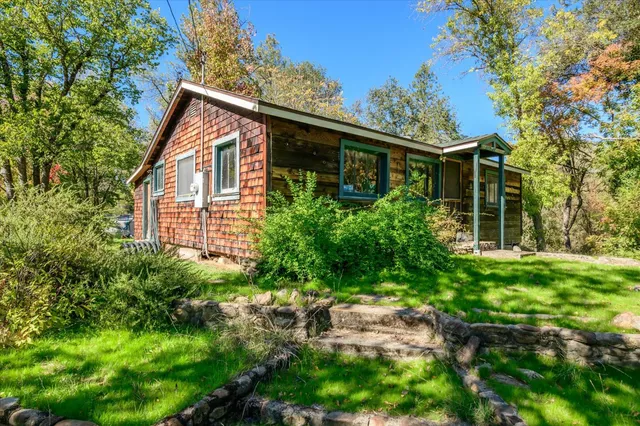 an aerial view of a houses with a lush green hillside