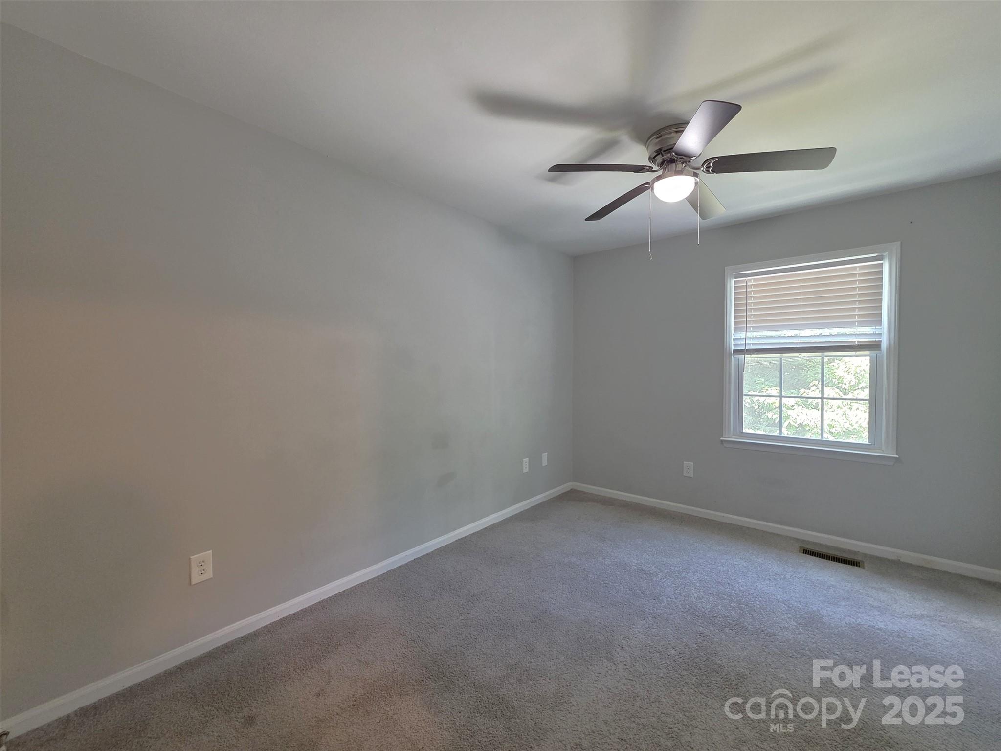 403 Spring Street Northwest Concord, NC 28025 - Photo 11 of 17 an empty room with a window and ceiling fan