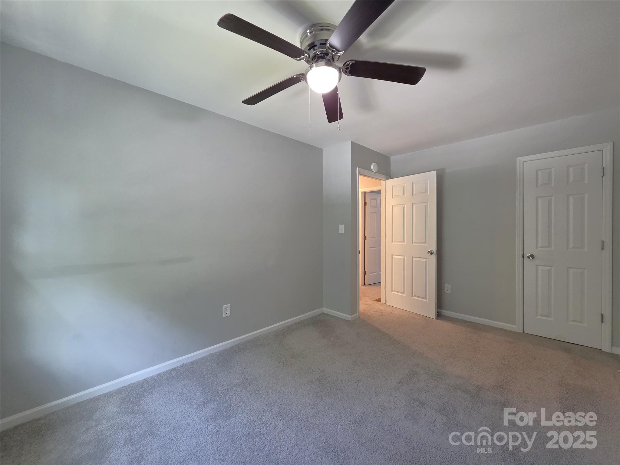 403 Spring Street Northwest Concord, NC 28025 - Photo 12 of 17 an empty room with a ceiling fan and a fan