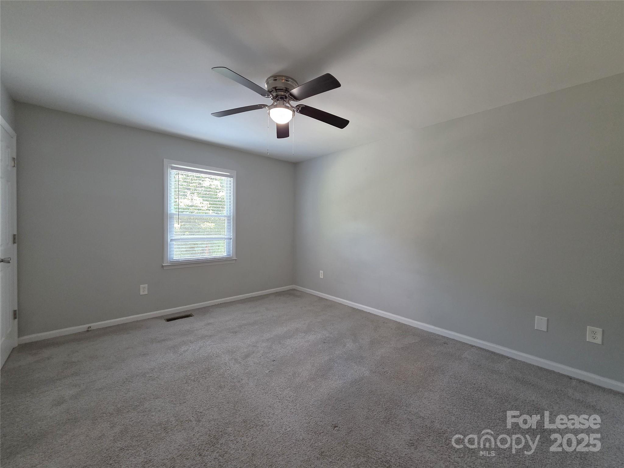 403 Spring Street Northwest Concord, NC 28025 - Photo 14 of 17 an empty room with a window and a fan