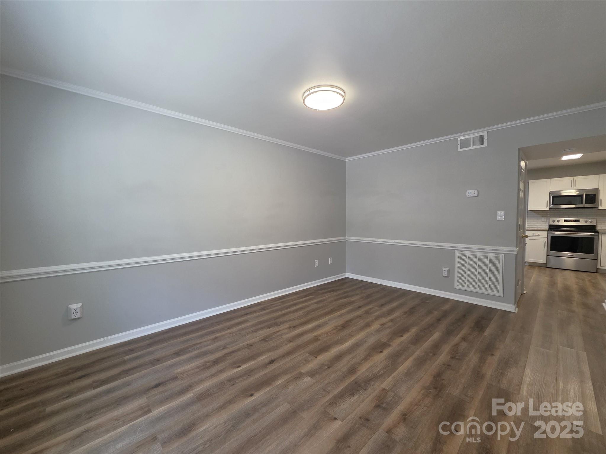 403 Spring Street Northwest Concord, NC 28025 - Photo 3 of 17 a view of an empty room with wooden floor