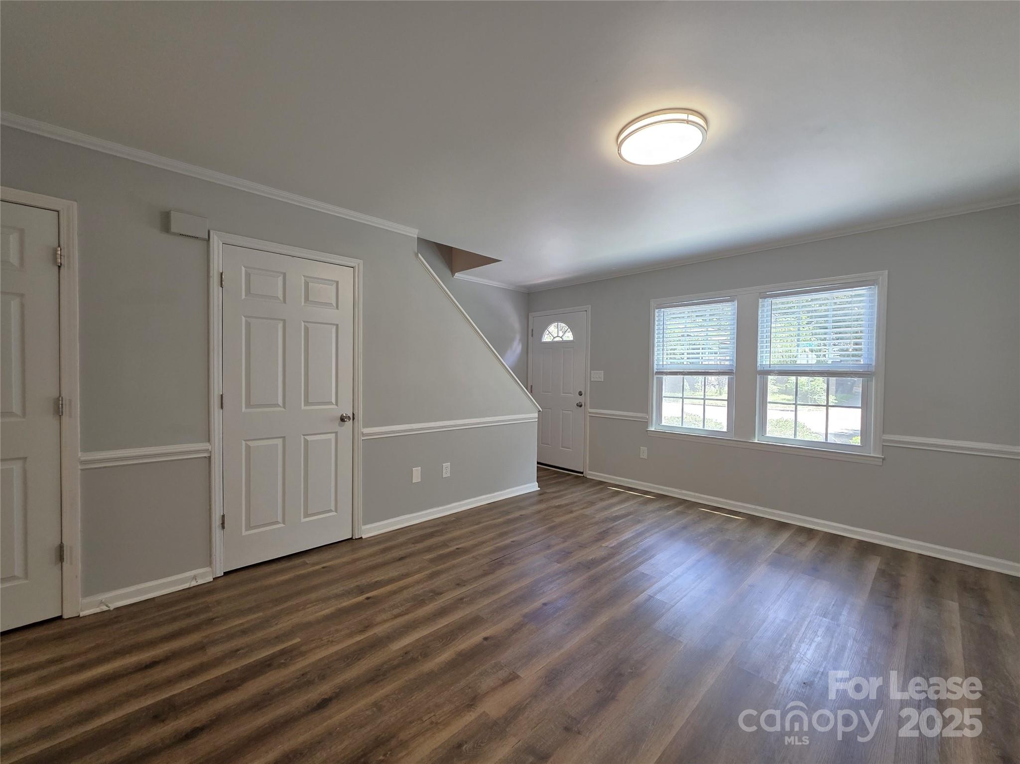 403 Spring Street Northwest Concord, NC 28025 - Photo 4 of 17 an empty room with wooden floor and windows