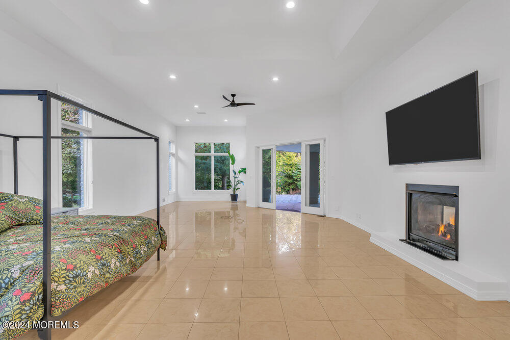 27 Revolutionary Road Colts Neck, NJ 07722 - Photo 31 of 77 a view of a bedroom with a bed and a flat screen tv
