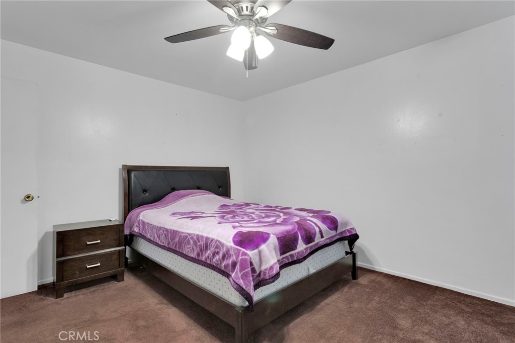 7925 Spohn Avenue Fontana, CA 92336 - Photo 14 of 25 a bedroom with a bed and a chandelier