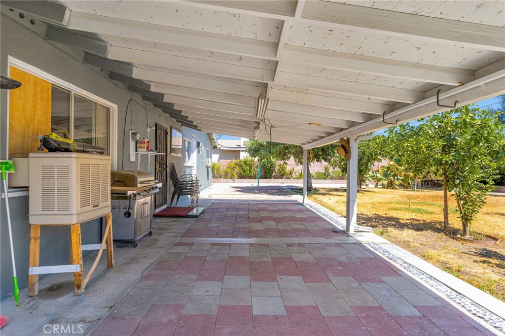 7925 Spohn Avenue Fontana, CA 92336 - Photo 18 of 25 a view of a patio with table and chairs a barbeque with wooden fence